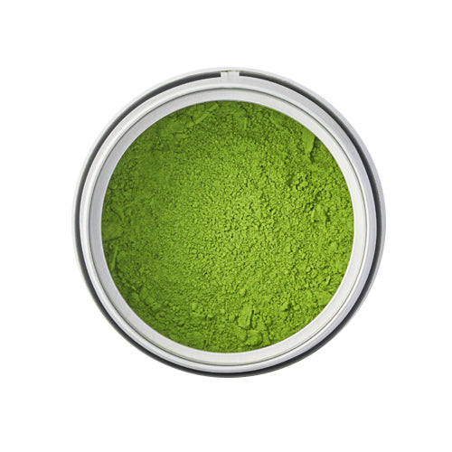 Green powder in a small metal container on a white background